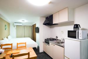 a small room with a kitchen and a bed and a table at Tutulu201 in Osaka