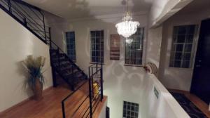 a staircase in a living room with a chandelier at Glow Boutique Hotel Zona G in Bogotá