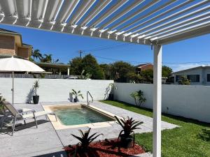 a white pergola over a swimming pool in a yard at Toowoon Bay - Private Pool - Outside Shower in Long Jetty