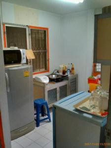 a kitchen with a refrigerator and a counter with a table at Social Style Culture in Bangkok