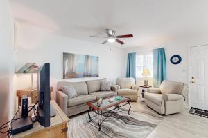 a living room with a couch and a tv at Atlantic Mist 103 in Ocean City