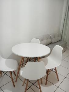 - une table et des chaises blanches dans une chambre avec un canapé dans l'établissement Aconchego da Barra, à Barra dos Coqueiros