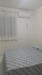 Ce lit se trouve dans un dortoir blanc doté d'une fenêtre. dans l'établissement Aconchego da Barra, à Barra dos Coqueiros