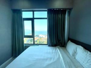 a bed in a bedroom with a large window at Mường Thanh Oceanus Apartment in Nha Trang