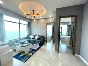 a living room with a blue couch and a chandelier at Mường Thanh Oceanus Apartment in Nha Trang