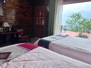 een slaapkamer met 2 bedden en een raam met uitzicht bij Eco Farmer House Sapa in Lao Cai