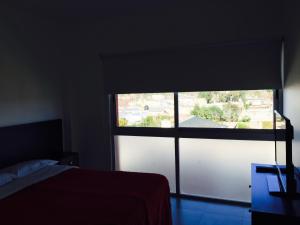 1 dormitorio con ventana y vistas a la calle en Apart Hotel Cañuelas en Cañuelas
