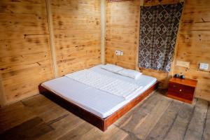 a bedroom with a bed in a wooden room at La Vie En Rose Ba Vì Homestay in Hanoi