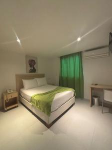 um quarto com uma cama e uma cortina verde em Hotel Isla Capri em Cartagena de Indias