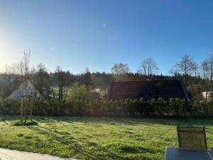 una vista de un campo con una casa en el fondo en Modernes Apartment am Waldrand en Geisenheim