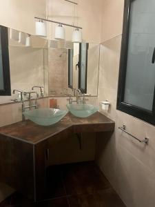 a bathroom with two sinks and a large mirror at Casona Valdivia en San Rafael in San Rafael