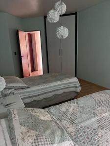 two beds in a room with a mirror at Casona Valdivia en San Rafael in San Rafael