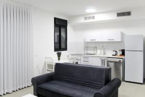 a living room with a couch and a kitchen at Luxury Family Apartment #26 By Hashdera Eilat in Eilat