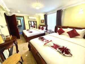 a hotel room with two beds and a desk at AHHA Boutique Kampot in Kampot