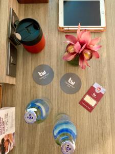 una mesa con un celular y una flor en ella en Thana Wisut Hotel - SHA Plus en Bangkok