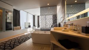 a bathroom with a tub and a sink and a television at Pullman Sydney Airport in Sydney