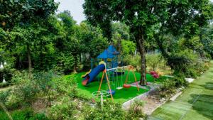 a playground with a slide in a garden at La Vie En Rose Ba Vì Homestay in Hanoi