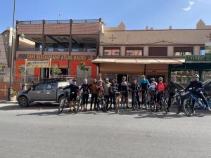 a group of people on bikes on a city street at Hôtel Riad Atlas Dades in Boumalne Dades