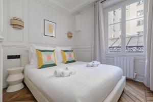 パリにあるPoetic Stay - Saint Lazareのベッドルーム1室(大きな白いベッド1台、タオル付)