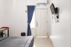 1 dormitorio con cama, ventana y puerta en RedDoorz Syariah near Lapangan Persijam Jambi en Palmerah