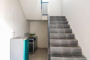 a staircase in a room with a refrigerator at RedDoorz Syariah near Lapangan Persijam Jambi in Paalmerah
