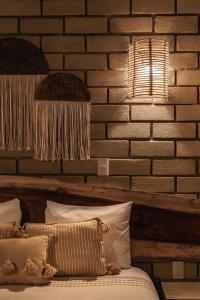 a bedroom with a brick wall with a bed and a lamp at Villa Macarena Apartamentos Boutique - Only Adults in Puerto Escondido