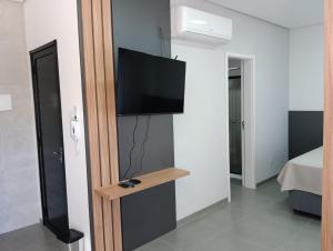 a room with a flat screen tv on a wall at Arambo Viagens e Hospedagens Loft 31 in Jaguarão