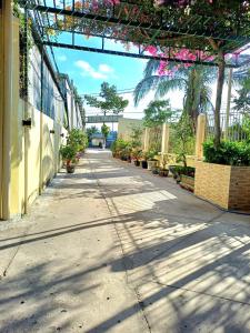 an empty sidewalk with plants and a pergola at NGUYỆT MINH HOTEL in Ấp Phú Lợi