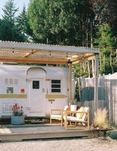 a trailer with two chairs and a table at Dreamy Airstream Hideaway with Hot Tub in Gibsons