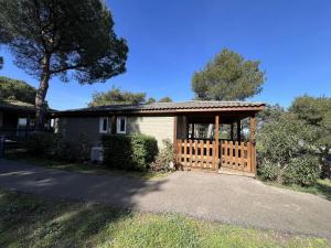 a house with a wooden gate in a yard at Chalet Agde, 3 pièces, 6 personnes - FR-1-702-63 in Agde