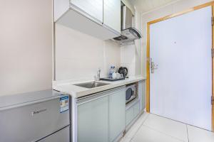 a small kitchen with a sink and a microwave at Meiru Apartment Hotel Guangzhou Bolin Apartment in Guangzhou