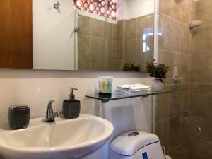 a bathroom with a sink and a toilet and a shower at Cabañas Annapurna in Taganga