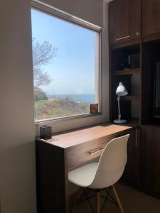 ventana en una habitación con escritorio y silla en Cabañas Annapurna en Taganga