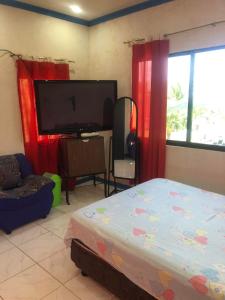 uma sala de estar com uma cama e uma televisão de ecrã plano em Hideaway Resort em Maraat