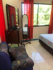 a bedroom with a chair and a dresser and a mirror at Hideaway Resort Victoria secret hideaway resort in Maraat