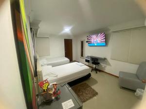 een ziekenhuiskamer met een bed en een tv bij La Casa Blanca Hotel in Buenaventura