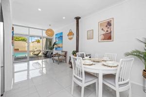 a dining room with a white table and chairs at Maylands Coastal Vibes in Perth