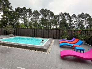 a swimming pool with two chairs and a person in it at Vergers de Nil les lauriers in Ban Chawuk