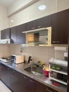 a kitchen with a sink and a microwave at Sister Hong's home in Jincheng