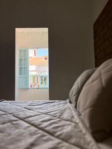 a bedroom with a bed and an open door at Encanto Azul en Villa in Villa de Leyva