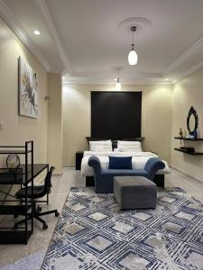 1 dormitorio con cama, mesa y alfombra en فيلا الوريك Villa Al Warik, en Umm Lajj