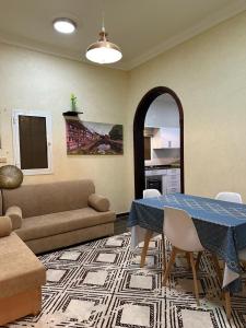 a living room with a table and a couch at فيلا الوريك Villa Al Warik in Umm Lajj