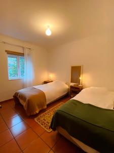 a bedroom with two beds and a window at CASAS NAS TERMAS in Cabeço de Vide