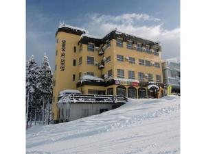 Ishiuchi Ski Center - Vacation STAY 09176v في Seki: مبنى أصفر كبير مع ثلج على الأرض