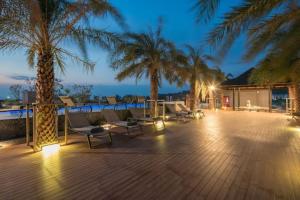 une terrasse avec des chaises et des palmiers la nuit dans l'établissement Luxury Resort City Gate Kamala C33, à Kamala Beach