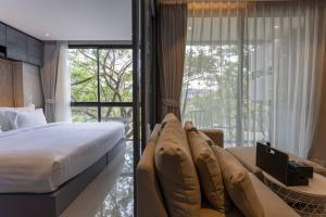 - une chambre avec un lit et un canapé en face d'une fenêtre dans l'établissement Luxury Resort City Gate Kamala C33, à Kamala Beach 34 autres photos