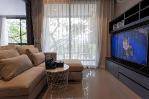 un salon avec un canapé et une télévision à écran plat dans l'établissement Luxury Resort City Gate Kamala C33, à Kamala Beach