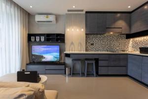 Il comprend un salon doté d'une cuisine et d'une télévision. dans l'établissement Luxury Resort City Gate Kamala C33, à Kamala Beach