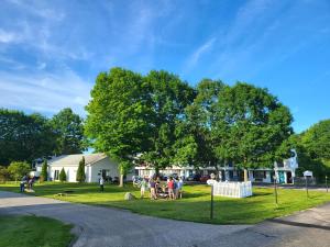 a group of people sitting in the grass near a house at Ocean Acres Ogunquit in Ogunquit