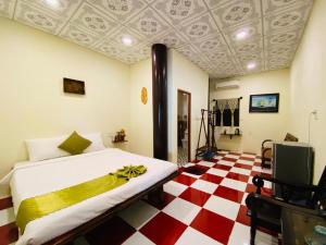 ein Schlafzimmer mit einem Bett und einem rot-weißen karierten Boden in der Unterkunft Phước Lạc Duyên Garden House by ACC in Ấp Thanh Sơn (1)